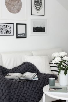 a blanket that is on top of a table next to a vase with flowers in it