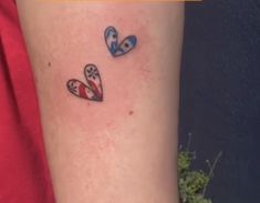 two small hearts on the arm with one red and one blue heart in between them