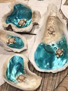 three sea shells with turtles in them on a table