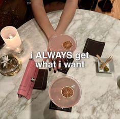 two people sitting at a table with wine glasses and plates on it that have orange slices in them