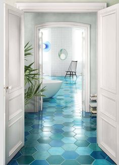 an open door leading to a bathroom with hexagonal tiles on the floor and walls