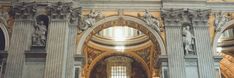 the inside of a church with statues and arches