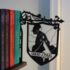 there is a book shelf with books on it and a sign that says, saah j maas