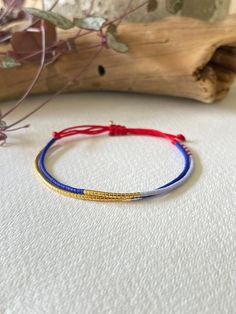 - This is a very classy Miyuki beaded bracelet to elevate your wrist game - This beaded layered bracelet features a stunning combination of royal blue, light blue and red Miyuki beads along with a line of gold plated miyuki beads, arranged on a vibrant red cord. - Its adjustable design ensures a comfortable fit, and its slim profile adds a touch of class to your look. - Perfect for any occasion, this bracelet is a chic and versatile accessory. - A red cord bracelet is often seen as a symbol of p Adjustable Beaded Bracelet, Miyuki Bracelet, Bracelet Christmas, Wrist Game, Cord Bracelet, Miyuki Beads, Cord Bracelets, Great Christmas Gifts, Blue And Gold