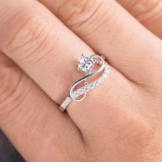 a woman's hand with a diamond ring on top of her finger and an engagement band