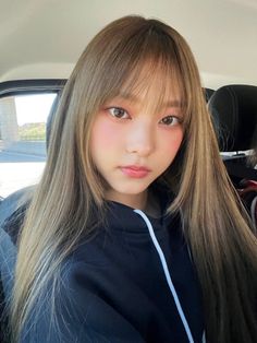 a woman with long hair sitting in a car