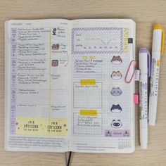 an open notebook with stickers and pens on it