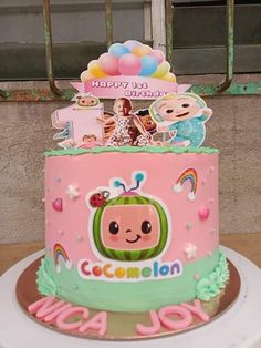 a pink and green cake with pictures on it