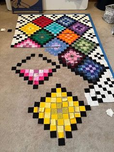 a large piece of art made out of lego blocks on the floor in front of a washing machine