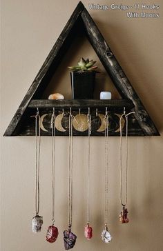 a triangle shaped shelf with several necklaces hanging from it