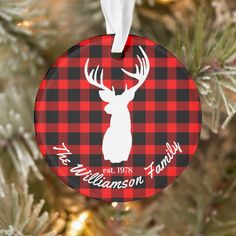 a christmas ornament hanging from a tree with a red and black plaid pattern