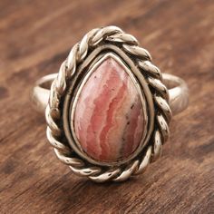 A pear-shaped rhodochrosite cabochon sits at the center of this simple yet elegant ring by India's Rakesh Rana. The natural stone is enclosed in a smooth, sterling silver bezel and accentuated with silver roping around the perimeter. Rhodochrosite Ring, Single Stone Ring, Garnet Pendant, Aqua Chalcedony, Pretty Necklaces, Single Stone, Garnet Stone, Ring Minimalist, Elegant Ring