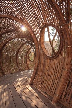 the inside of a bamboo structure with circular mirrors on it's sides and wood flooring