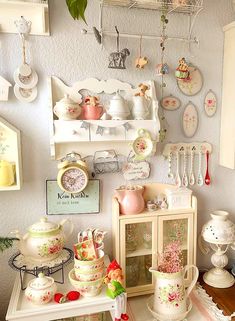 there are many dishes and cups on the shelves in this room, including teapots