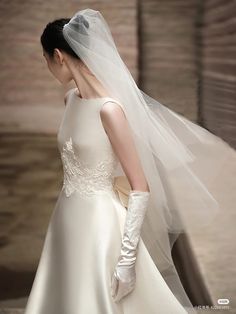 a woman in a white wedding dress and veil