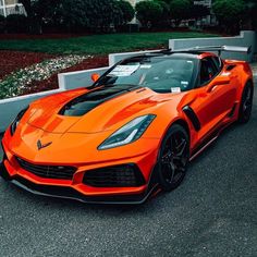 an orange sports car is parked on the street