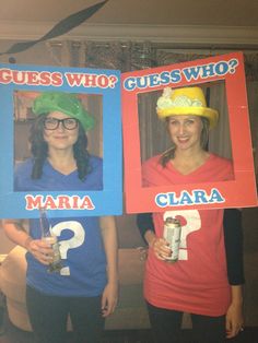 two women in matching shirts and hats are holding up signs with question marks on them