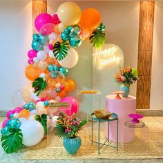 balloons, flowers and other decorations are on display at the entrance to a birthday party