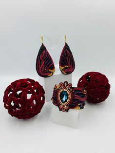 Shibori silk ribbon jewelry set "Carmen" embroidered by hand. In center of bracelet is Swarovski dark blue Crystal embroidered with Shibori silk ribbon and glass beads. Also our master used red and black round Swarovski crystals.  Back side of earrings and bracelet covered with Napa leather.  Hooks of earrings is gold plated.         This exquisite silk ribbon is hand made with an traditional Japanese dyeing technique called Shibori. The ribbon is made using the Arashi Shibori technique, also ca Handmade Evening Bracelet Jewelry, Handmade Adjustable Jewelry For Evening, Adjustable Handmade Bracelets For Evening, Elegant Bracelets With Matching Earrings For Party, Silk Ribbon Jewelry, Arashi Shibori, Silk Earrings, Shibori Ribbon, Ribbon Bracelet