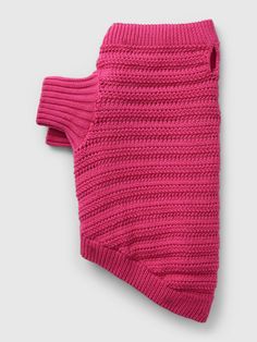 a pink knitted dog sweater on a white background