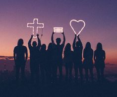 a group of people holding up crosses and hearts