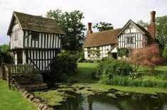 an old style house next to a small pond