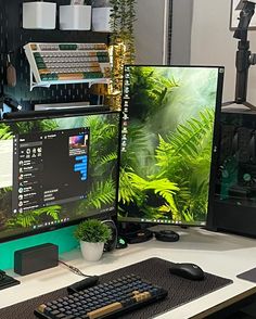 two computer monitors sitting on top of a desk next to a keyboard and monitor screen