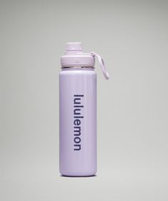 a purple water bottle sitting on top of a white table next to a gray wall