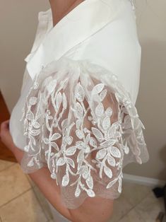 the back of a woman's dress with white flowers on it and sheer fabric