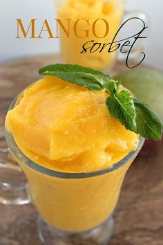 mango sorbet with mint garnish in glass on wooden table