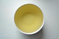 a white bowl filled with yellow liquid on top of a table