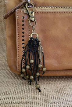 a brown leather purse with tassels and beads