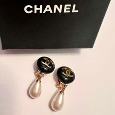 Vintage Chanel Cc Dangle Clip-On Earrings. Circa 1995. Made In France. Black With Iconic Gold Cc Interlocking Logo. Faux Pearl Dangle. Measures 1.5" In Length. Due To Vintage Age, There Are Some Slight Scratches And Indentations. Hardware Has Minimal Tarnishing. Comes With Certificate Of Authenticity. Please See Photos For Wear. Jewelry Chanel, Chanel Earrings, Chanel Jewelry, Vintage Chanel, Earrings Color, Made In France, Faux Pearl, Clip On Earrings, Jewelry Earrings