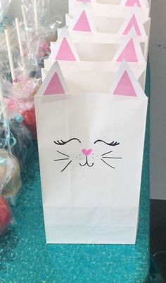 a paper bag with a cat's face on it and candy in the background