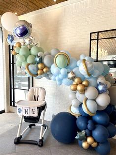 a balloon arch with blue, gold and white balloons