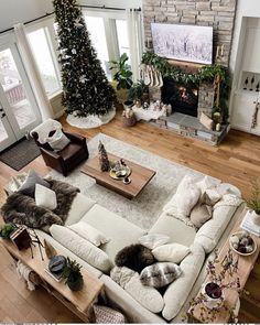 an aerial view of a living room with christmas trees and decorations on the fireplace mantel