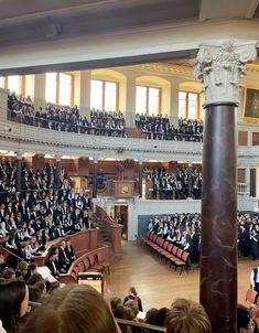 a large group of people sitting in front of an audience at a graduation ceremony,