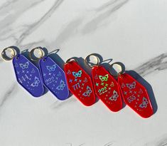 four different colored dog tags on a marble surface