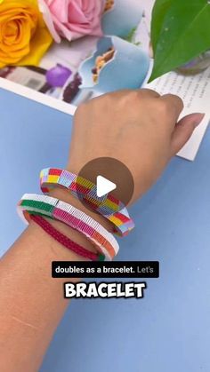 a woman's hand holding several bracelets with flowers in the background and text that reads, doubles as a bracelet let's bracelet