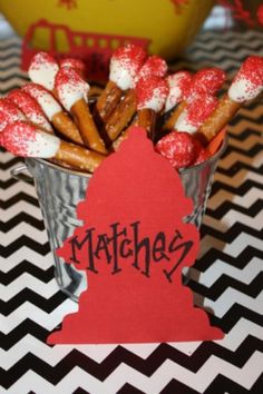 a cup filled with candy covered pretzels sitting on top of a table