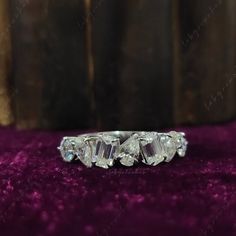 three stone diamond ring sitting on purple velvet