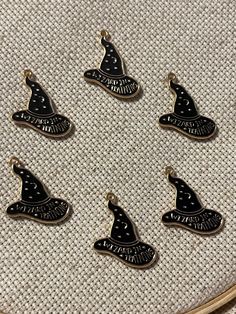 six black witches hats on a white cloth with the words halloween written in gold letters