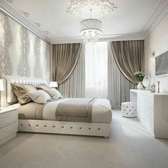 a bedroom with a bed, dresser and chandelier in the middle of it