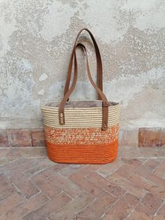 The woven straw bag is a straw bag with leather handles perfect as a gift for women. This Moroccan basket handcrafted with natural straw and combined with leather, makes it a lovely straw handbag as a gift for women. you can use your straw bag for everyday use, always with style and authenticity. It can be a nice gift for women as a gift or for yourself. The length of the handles is adjustable Dimension Width 30cm Height 24cm Depth 13cm Elegant Woven Straw Tote Bag, Woven Top Handle Beach Bag For Shopping, Woven Top Handle Beach Bag, Elegant Woven Straw Bag, Elegant Natural Straw Tote Bag, Elegant Woven Natural Fiber Straw Bag, Eco-friendly Orange Rectangular Straw Bag, Natural Fiber Shopping Bags, Woven Straw Top Handle Bag For Shopping