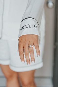 a woman's hand with a wedding ring on her left wrist and the date printed on it