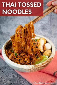 a bowl filled with noodles and chopsticks on top of a pink napkin next to a