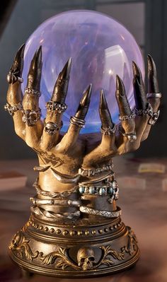 a crystal ball with claws on it sitting on top of a table