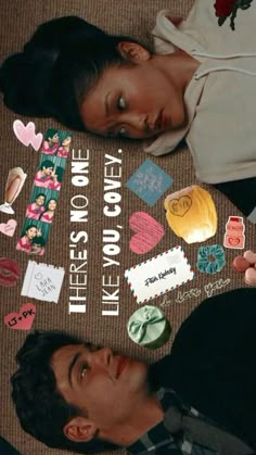 a man and woman laying on the ground next to each other with paper hearts around them