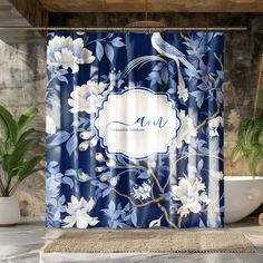 a blue shower curtain with white flowers on it and a bird perched on the branch