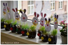 some plants are sitting on a window sill in front of the windowsill and decorated with easter bunnies